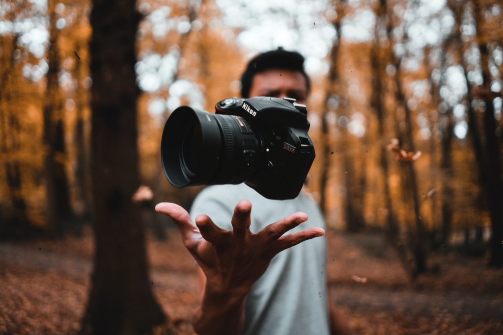 A man throwing a camera